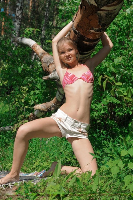 Petite teenage looker Bridgit strips down in the middle of the woods