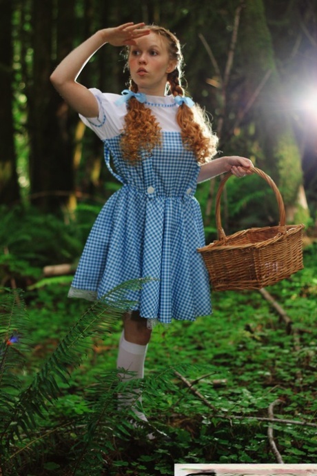 Charming redhead teen Dolly Little gets naked in white socks while in a forest