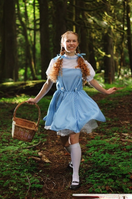 Charming redhead teen Dolly Little gets naked in white socks while in a forest