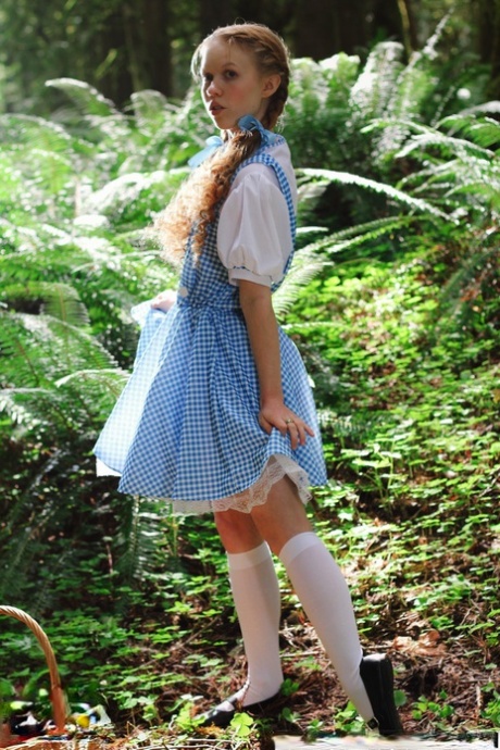 Charming redhead teen Dolly Little gets naked in white socks while in a forest