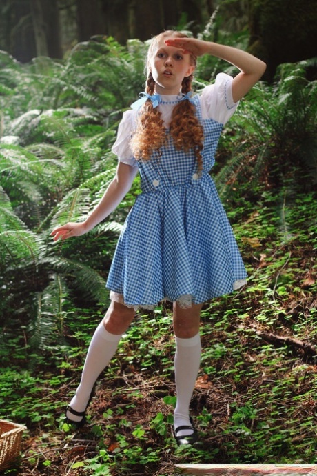 Charming redhead teen Dolly Little gets naked in white socks while in a forest
