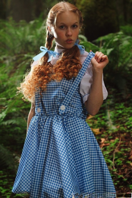 Charming redhead teen Dolly Little gets naked in white socks while in a forest