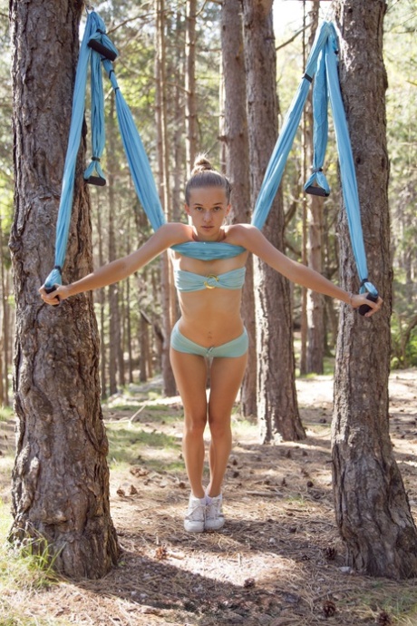 Marvelous babe Milena Angel strips naked & poses while swinging in the forest