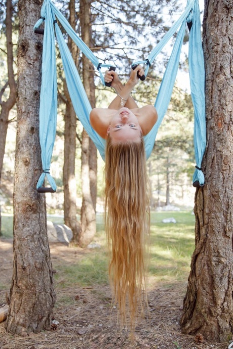 Marvelous babe Milena Angel strips naked & poses while swinging in the forest